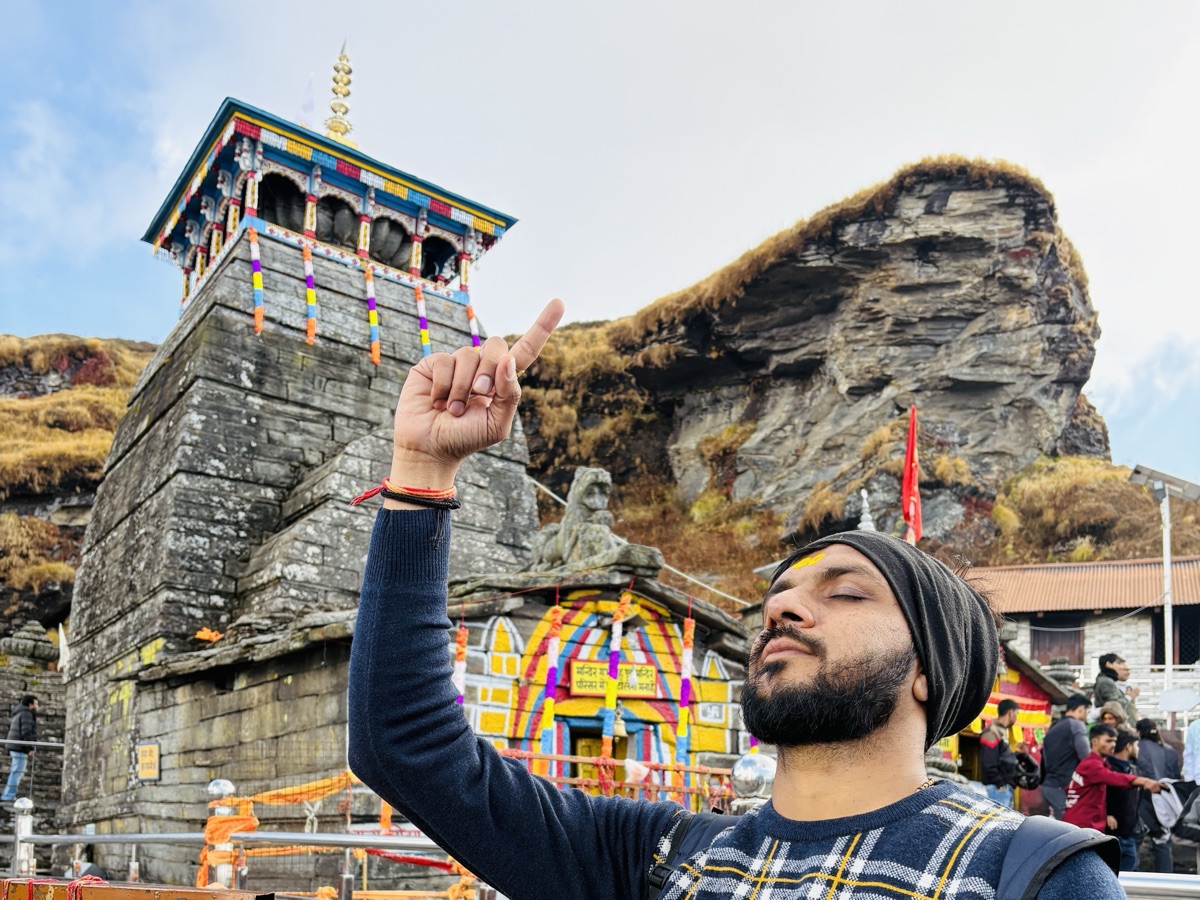 Pratik at Tungnath temple with a tilak on his forehead, eyes closed and one finger raised to the sky